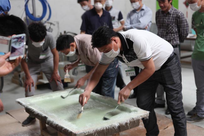 噴涂完成后，用輥筒壓實玻纖